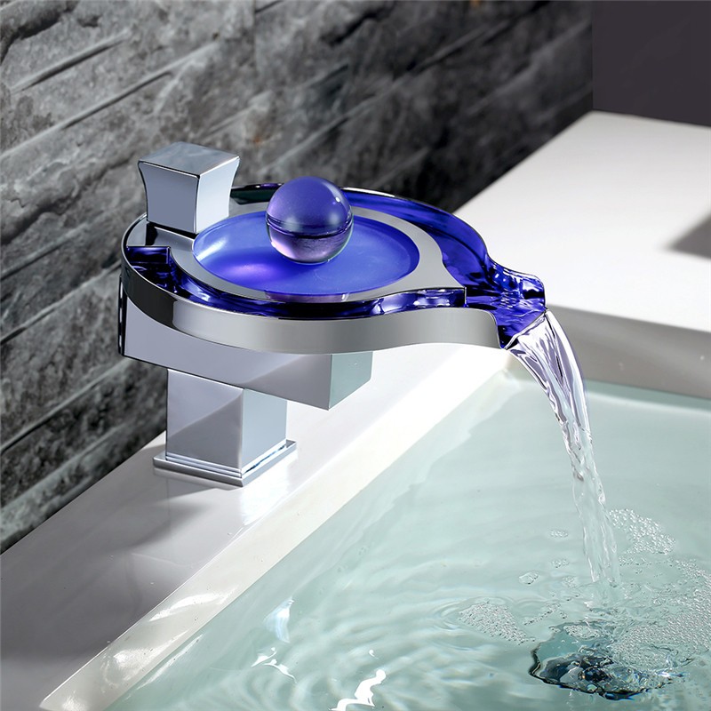 A modern bathroom with a stylish, illuminated LED faucet.