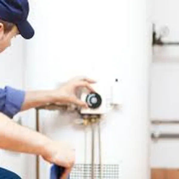 A professional plumber working on a water heater repair.